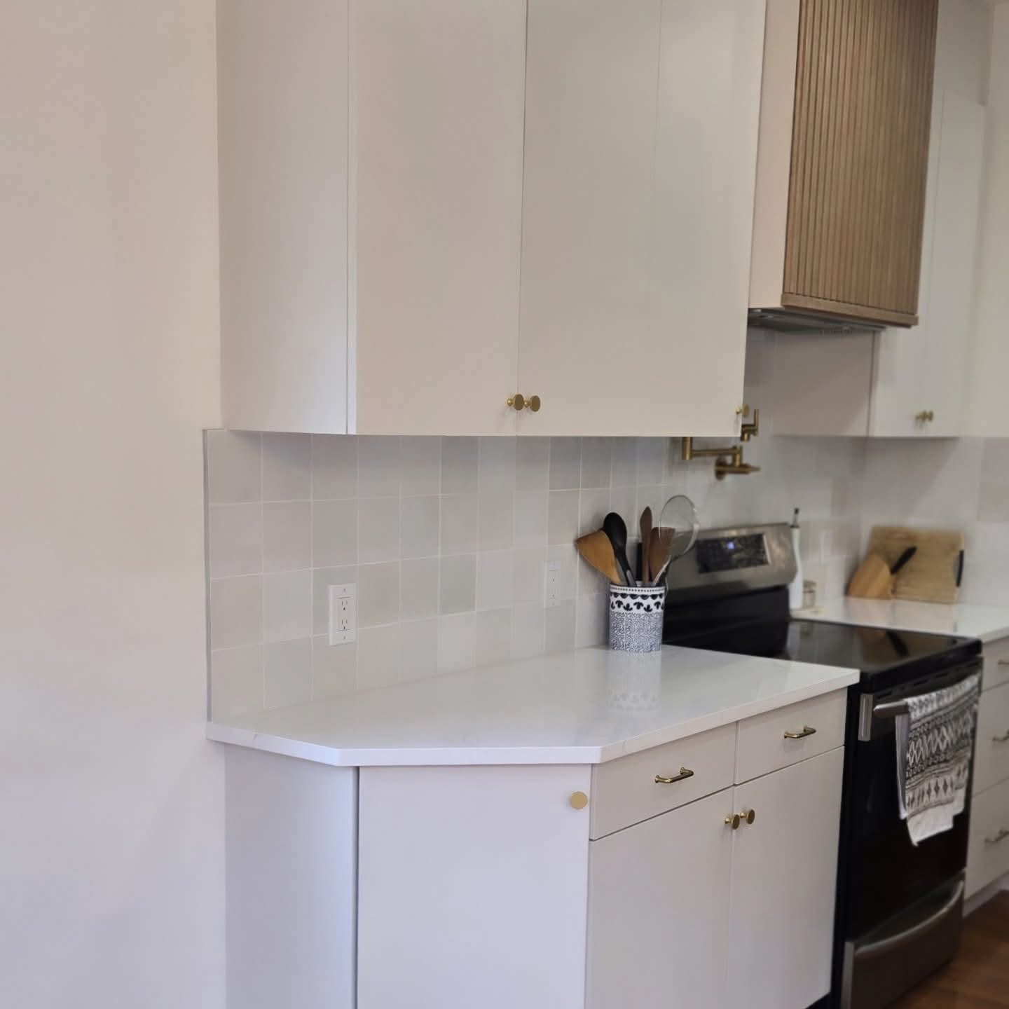 Refinished white kitchen cabinets with brass hardware in Kensington, Calgary Refinished white kitchen cabinets with brass hardware in Kensington, Calgary